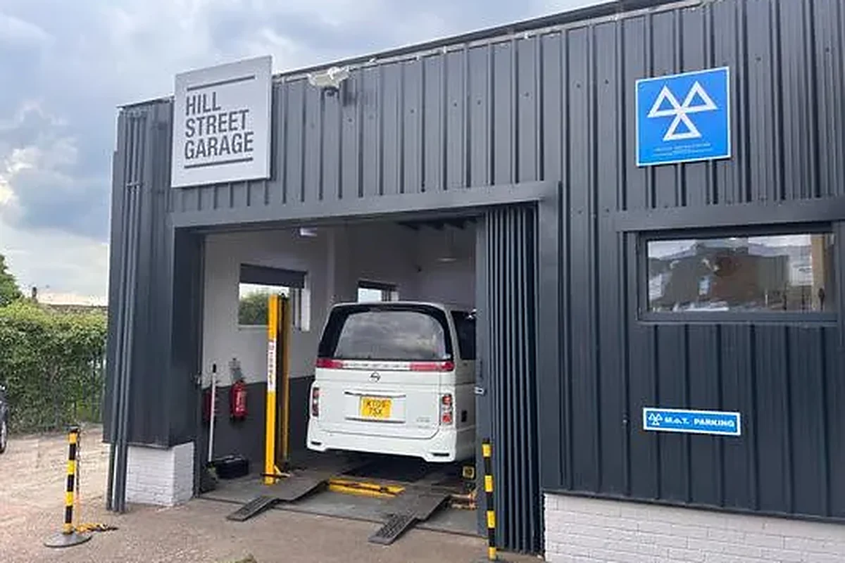 The front of the Worksop workshop, with the DVSA MOT testing station sign and a van up on the ramp